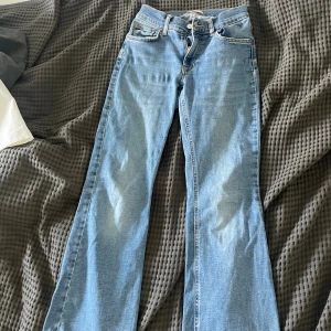 Ljusblå bootcut jeans från Gina perfect - Säljer ett par ljusblå jeans från Gina perfect jeans i klassisk bootcut-modell. Jeansen har fem fickor, bälteshällor och dragkedja med knapp. Snyggt utsvängda ben och klassisk denim-look, perfekta till sneakers eller boots.