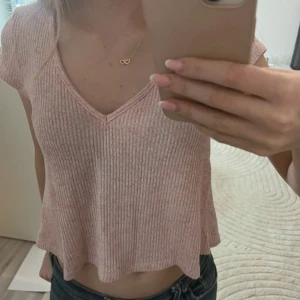 Rosa topp från Gina Tricot - Supersöt ljusrosa ribbad topp från Gina Tricot i storlek S. Modellen är lite croppad med v-ringning och korta ärmar. Materialet är mjukt och stretchigt. Helt ny utan prislapp, aldrig använd.💗