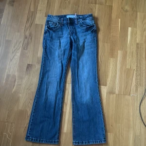 Blå bootcut jeans från S.Oliver - Säljer ett par klassiska blå jeans från S.Oliver med bootcut-modell. Jeansen har fem fickor, normal midja och snygga söm-detaljer på bakfickorna. Tillverkade i jeansmaterial som ger en tidlös look. Perfekta till sneakers eller boots.