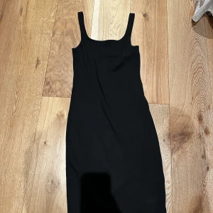 Svart cocktail klänning  - Svart kort coctail klänning från Bik Bok i storlek XS. Klänningen har en stilren, tight passform med breda axelband och en liten slits bak. 