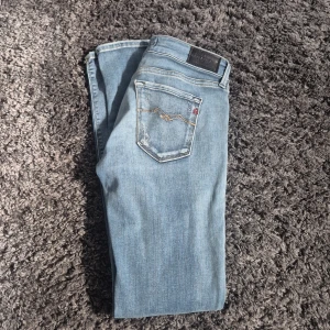 Ljusblå Replay jeans, storlek 25 - Snygga ljusblå jeans från Replay i klassisk femficksmodell. Jeansen har raka ben, normal passform och coola detaljer på bakfickorna med guldfärgad söm. Perfekta till sneakers eller boots och tillverkade i mjukt jeanstyg för en skön känsla.