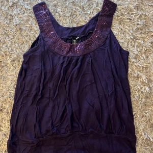 Lila paljettlinne - Lila linne med glitter detaljer.