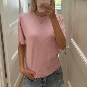 Ljusrosa stickad kortärmad tröja - Superfin ljusrosa stickad tröja med korta ärmar. 100% Kashmir från Filippa K💗 storlek S. Har ett sytt hål (se bild 3)