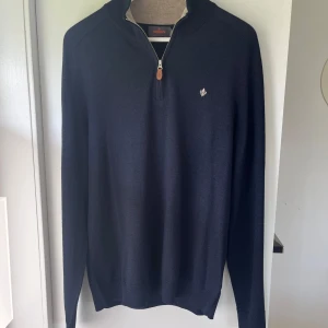 Morris marinblå halvziptröja i ull - Snygg marinblå tröja från Morris med halv dragkedja och diskret logga på bröstet. Tillverkad i mjuk ull, perfekt för lager-på-lager. Långärmad modell med ribbade muddar och krage i kontrastfärg. Aldrig använd. Bara att höra av sig vid eventuella frågor!😉