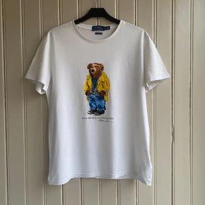 Ralph Lauren polo bear t-shirt - En mycket snygg t-shirt inför sommaren. Dock ett litet hål 0.3•0,3cm som du kan se på näst sista bilden. Men det är verkligen ingenting som märks när man bär den👍👍.   Tveka inte på om du har några frågor!!💬💬