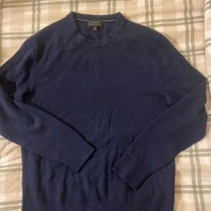 Merino tröja - Säljer en mörkblå tröja från Banana Republic i 100% merinoull. Tröjan har långa ärmar och en klassisk rund halsringning. Perfekt för kyligare dagar och ger en elegant touch till din outfit.