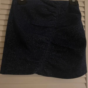 Blå glittrig kjol - En jättefin blå kjol med glitter från Zara, kedja på sidan. Knappt använd och har inga skador eller defekter! 