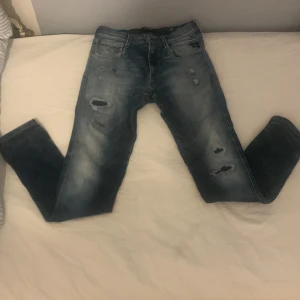 Replay jeans med slitningar - Snygga blå jeans från Replay med slitningar för en trendig look. De har en klassisk femficksdesign och en bekväm passform. Perfekta för en avslappnad stil. Nypris cirka 1799 mitt pris 499 uppen för bud.