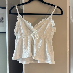 Vit topp med volang  - Jätte söt topp💞perfekt nu i sommar. Använd några gånger men har inga defekter.