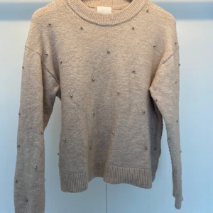 Stickad tröja - Beige stickad tröja med pärlor på. Är synligt använd men inte i dåligt skick. Skriv vid frågor!