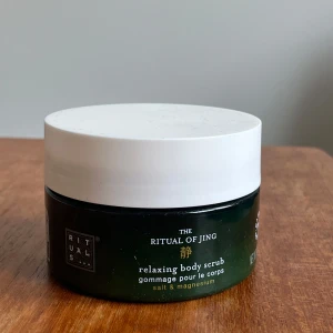 The Ritual of Jing Relaxing Body Scrub - Oanvänd. Avkopplande kroppsskrubb från Rituals med salt och magnesium. Perfekt för att ge huden en mjuk och len känsla. Kommer i en stilren burk med vit lock.