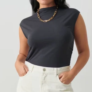 Grå ärmlös topp - Snygg grå ärmlös topp med hög hals. Perfekt för en stilren look. Tillverkad i ett mjukt och stretchigt material som ger en bekväm passform.