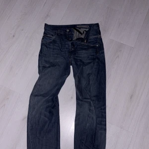 Levi's Engineered Jeans - Snygga Levi's Engineered Jeans i en klassisk blå denim. Byxorna har en normal passform med dragkedja och knappar. Perfekta för en avslappnad stil med sina ikoniska bakfickor och detaljer.