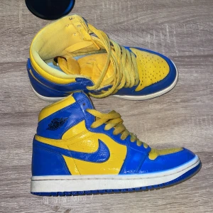 Nike Air Jordans i blått och gult - Snygga Nike Air Jordans i en iögonfallande blå och gul färgkombination. Skorna har klassisk snörning och en hög siluett som ger extra stöd. Det är köpta i LAS vegas i en skobutik och skorna är äkta.