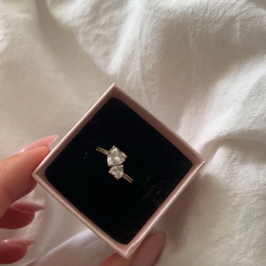 Pandora ring - Jättefin pandora ring, guldfärgad med en stor hjärtformad klar sten i mitten och mindre stenar på sidorna. 