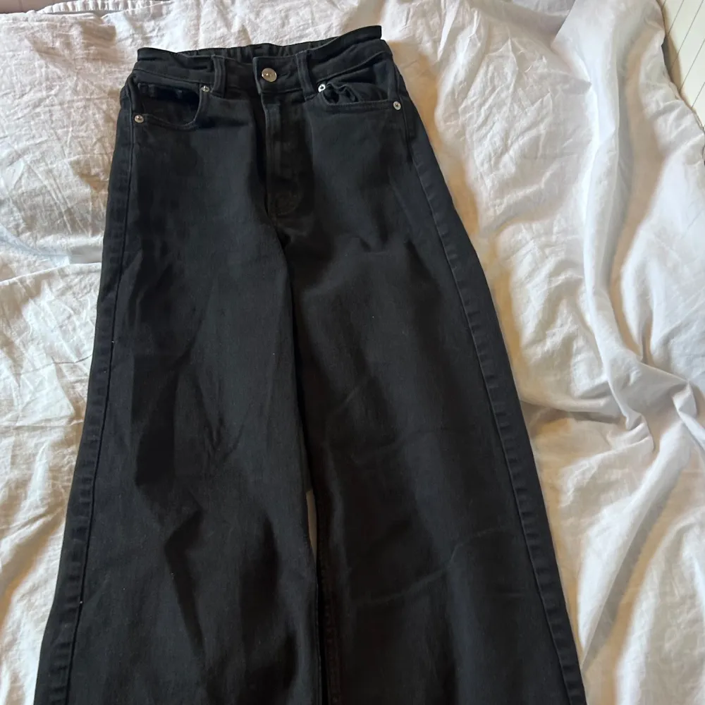Snygga svarta jeansbyxor med hög midja och raka ben. De har en klassisk femficksdesign och stängs med dragkedja och knapp. Perfekta för en stilren look.. Farkut & Housut.