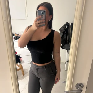 Svart glittrig oneshoulder topp - Snygg svart glittrig oneshoulder topp. Stretchig i materialet. Från Vila.