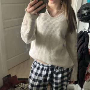 Vit ribbad tröja - Säljer en stilren vit ribbad tröja med v-ringning. Tröjan har långa ärmar och är perfekt för en avslappnad look. Passar bra till både jeans och kjol. Perfekt för kyligare dagar!