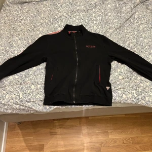 Guess tröja - Guess tröja med dragkedja. Tröjan är i bra skick inga skador, märks däremot att den använts. 