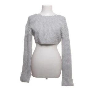 Grå croppad tröja från Gina Tricot - Grå ribbad tröja från Gina Tricot. Den är croppad med långa ärmar och har en avslappnad passform. 