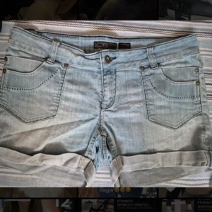 Ljusblå jeansshorts från Only - Snygga ljusblå jeansshorts från Only med klassisk femficksdesign och uppvikta benslut. Perfekta för en avslappnad stil. 
