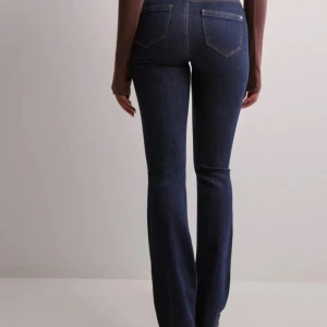 Mörkblå bootcut jeans från ONLY - Snygga mörkblå bootcut jeans från ONLY med hög midja. Klassisk femficksdesign och dragkedja med knapp framtill. Perfekta för en stilren look. Storlek S, längd 32