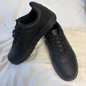 Svarta sneakers från SOC - Snygga svarta sneakers från SOC i skinn med en robust sula och klassisk snörning. Perfekta för en stilren look och bekväma för vardagsbruk.