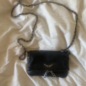 Svart Zadig & Voltaire väska  - Säljer min älskade och trendiga Zadig Rock Nano Grained Leather väska då den tyvärr inte kommer till användning längre. Tidigare köpt ny men har lite rost på Zadigvingarna (se bild 3) därav priset❣️❣️