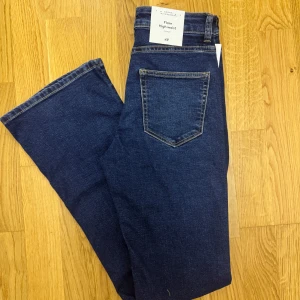 Mörkblå flare jeans från H&M - Säljer ett par mörkblåa flare jeans från H&M med hög midja men har inga öppna fickor fram till .