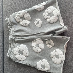 Denim tears shorts - Grå mjuka shorts från Denim Tears med vita blommor. Skick 10/10, använda 1 gång och är extremt bekväma, hör av er vid intresse av köp!😃