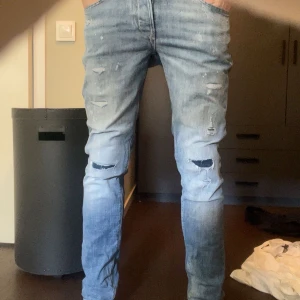 Ljusblå slitna jeans Slim/Glenn - Säljer ett par ljusblå jeans med slitningar från Jack & Jones. Storlek 29/32 och modellen är slim/glenn. Jeansen är i nyskick och knappast använda. Priset är diskuterbart och det är bara höra av dig vid fler frågor