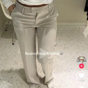 Beige kostymbyxor från BikBok - Stilrena beige kostymbyxor från BikBok med normal passform och raka ben. Byxorna har hällor för bälte och klassisk midja. Perfekta för en clean och enkel look.