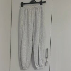 Ljusgrå mjukisbyxor med resår - Ljusgrå mjukisbyxor med elastisk midja och muddar vid bensluten Byxorna har en avslappnad passform och är tillverkade i mjukt bomullsmaterial. Perfekta för en chill och bekväm stil. De går också att vi ner vid midjan. Ser mycket bättre ut på.