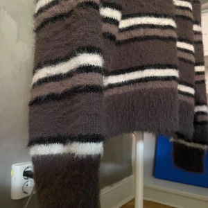 Fluffig randig tröja från Weekday - Supermjuk och fluffig brun tröja från Weekday med vita och svarta ränder. Tröjan har lång ärm och avslappnad passform, storlek man xs men passar mer som medium. Perfekt för mysiga dagar och sommarkvällar. Materialet känns lyxigt och gosigt. 