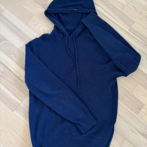 Kashmirhoodie - Mörkblå Kashmirhoodie i lyxig från 7 for all mankind. Tröjan har huva med och långa ärmar. Perfekt för dig som gillar en klassisk och stilren look med extra komfort. Ny på deras hemsida kostar den drygt 3000kr.  Den är använd endast några gånger och vårdad som en Kashmirtröja ska vårdas. Hör av er vid minsta fråga och pruta gärna 😊