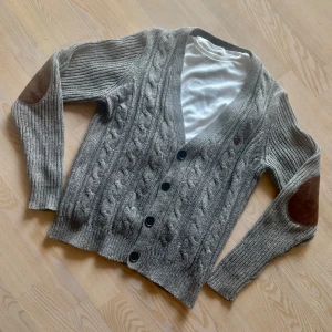 Stickad Kofta  - En sjukt stilren och skön kofta med elbow-patches! En helt perfekt kofta inför våren och sommarens lite kyligare dagar! Storlek S passar tts! Om ni har frågor eller funderingar är det bara att höra av sig!