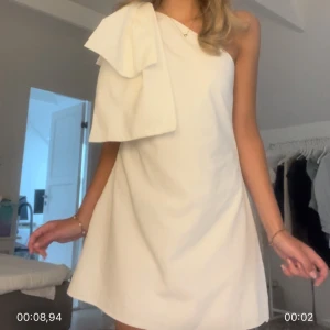 Vit oneshoulder-klänning med rosett från Showpo - Säljer min fina studentklänning från Showpo som är oneshoulder med en rosett på axeln. Klänningen är använd men inget som syns. Så himla fin studentklänning 🩷🩷🩷