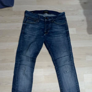 Blå jeans från Jack & Jones - Säljer ett par klassiska blå jeans från Jack & Jones med slim/glenn passform. Jeansen är sjukt sköna och stretchiga och har dessutom en avslappnad tvättad look. Jeansen har inga synliga slitage och är i bra skick. Storlek W29 L30. Skriv gärna vid minsta fråga, pris kan diskuteras.