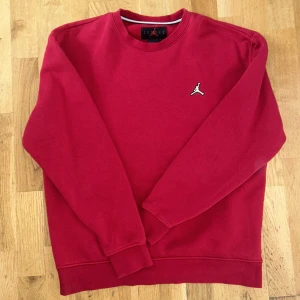 Röd crewneck sweatshirt från Jordan - Säljer en röd crewneck sweatshirt från Jordan med klassisk Jumpman-logga broderad på bröstet. Tröjan har rund halsringning och långa ärmar. Perfekt för en sportig och avslappnad stil.