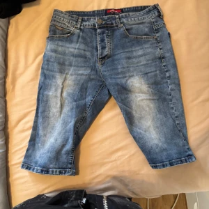 Blå jeansshorts från Fixxe - Säljer ett par klassiska blå jeansshorts från Fixxe. De har fem fickor, knapp och dragkedja framtill samt en normal passform. Perfekta för varma dagar och enkla att matcha med olika toppar.