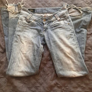 Ljusblå jeans från Lee med raka ben - Säljer ett par ljusblå jeans från Lee med raka ben och klassisk femficksdesign. Jeansen har röda sömmar vid fickorna. Passar dig som gillar en avslappnad och tidlös stil. Står ingen storlek. Har ett litet hål vid rumpan men tror det är lätt o fixa, ska själv försöka fixa de. Slitna längst ner vid benen då jag gått på dom💞