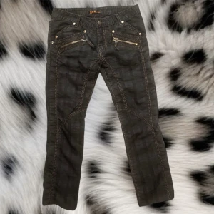 K&M jeans - Super coola kosmo lupo jeans med rutigt mörkt mönster och dragkejdor framtill och baktill❤️inga defekter och ser nya ut❤️midjan: 44cmx2, totallängd:100cm, innerbenslängden: 77cm, benöppningen: 20cm x2