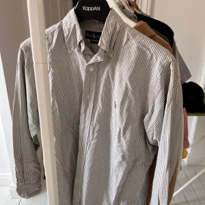 Ralph Lauren skjorta - Riktigt snygg Ralph Lauren skjorta som är grårandig. Skick 9/10, nån liten prick på magen som tas bort genom tvättmaskin, nypris 1300kr. Hör av dig vid funderingar 👍