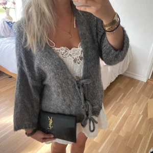 Grå stickad cardigan med knyt🤍🥐 - Mysig grå stickad cardigan med breda ärmar och två knytband framtill. Jackan har en avslappnad passform och är perfekt att slänga över en klänning eller topp. Den är fluffig och har en snygg, enkel design som passar till många outfits. MOHAIR 🤍🥐🧖🏼‍♀️