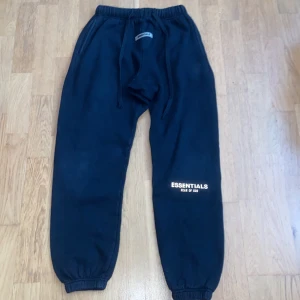 Essentials mjukisbyxor Svart - Svarta mjukisbyxor från Essentials Fear of God med broderad logga på benet. Gjorda i 100% bomull och i storlek M men har krympt lite på grund av att jag har tvättad dom flera gånger. Bra skick.