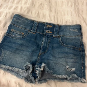 jeans shorts  - säljer ett oar jeans shorts i marinblå. från hm. vet inte storleken här heller men de är lite små för mig så skulle även säga xxxs!! hålen i shortsen är gjorde i fabrik. så det är inte jag som gjort hål. dm för frågor om mått eller annat