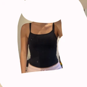 Svart enkel linnetopp med smala band - svart, tight linnetopp med smala axelband och rak halsringning. Toppen är basic och funkar till allt, perfekt att styla med jeans eller kjol. Mjuk och stretchig känsla, sitter snyggt och följer kroppen. Passar storlek S och M. 