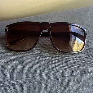 Bruna fyrkantiga solglasögon - Snygga solglasögon med bred, fyrkantig båge i mörkbrunt plastmaterial. Glasen är tonade i brunt och ger en cool retrovibe. Perfekta för att lyfta din stil under soliga dagar.