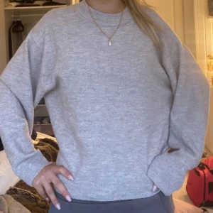 Beige stickad tröja från H&M - Enkel och stilren ljusgrå stickad tröja från H&M. Tröjan har rund halsringning, långa ärmar och ribbade muddar. Perfekt för lager-på-lager och passar till allt. Mjuk och skön att bära, loose fit för en avslappnad vibe. Smått nopprig men fint skick och jätteskön. Haft länge men syns inte.
