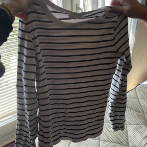 Randig långärmad tröja från Gina Tricot - Säljer en vit och svart randig långärmad tröja från Gina Tricot, basically basic-kollektionen. Tröjan är ribbad och har en klassisk rund halsringning. Perfekt för dig som gillar en enkel och stilren look. Etiketten har tydlig syn på tvätt (se bild) men inget man tänker på